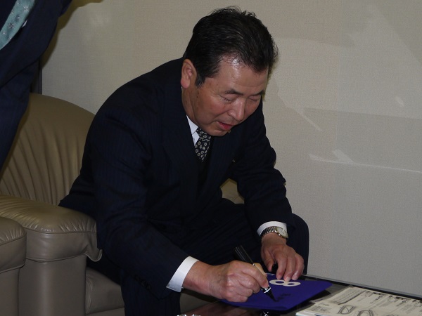 サイン中の橋口弘次郎調教師